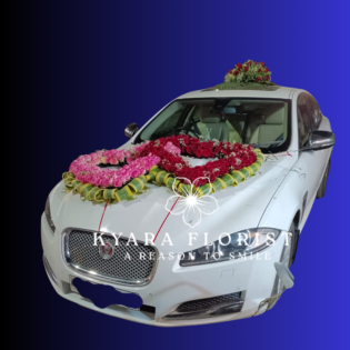 Double heart red and pink rose floral decoration on a white Jaguar car